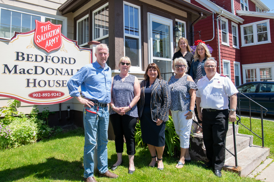 (front row) Mike Redmond, Dr. Janis MacLellan-Peters, Dr. Jo-Ann MacDonald, Kathy Walsh, and Major Dan Roode. (back row) Jennifer Balderston and Lauren Murphy People stand in front of Bedford MacDonald House