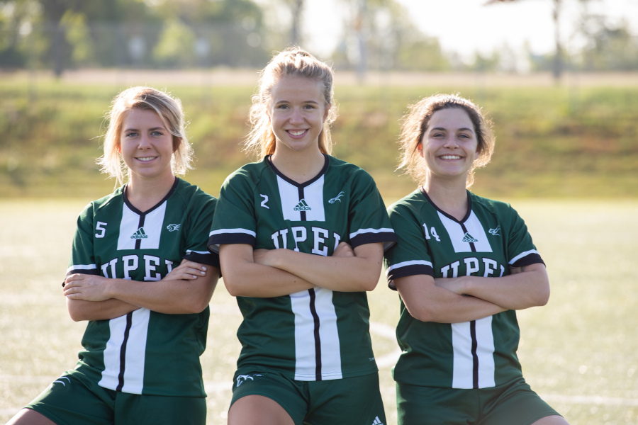 UPEI women's soccer plays its home opening game Friday Three smiling female soccer players