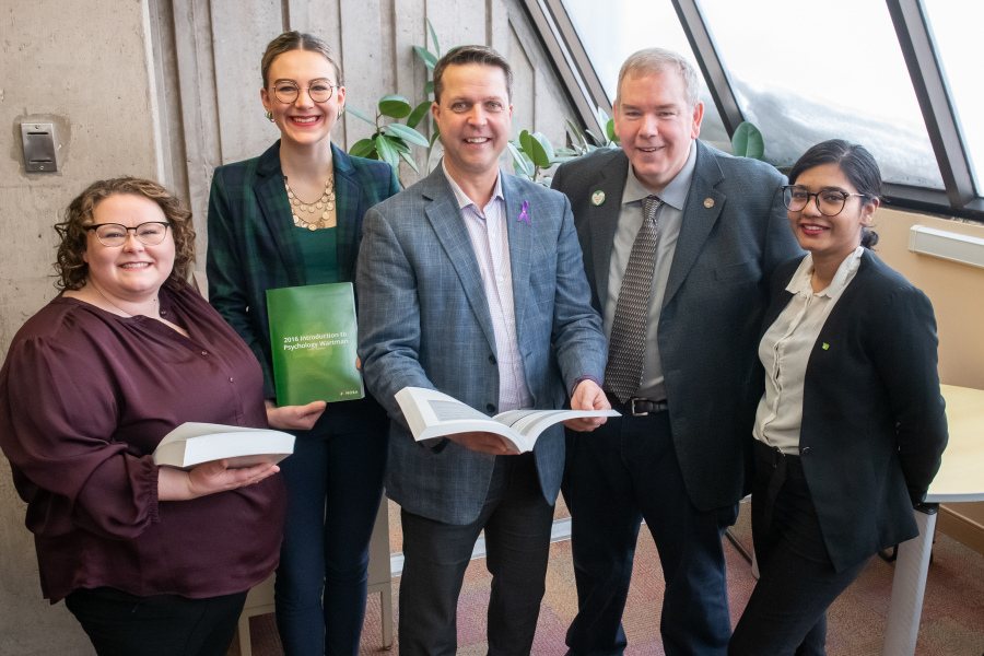 Kim Mears, Health Sciences & Scholarly Communications Librarian; Emma Drake, President, UPEISU; Honourable Brad Trivers, Minister of Education and Lifelong Learning; Donald Moses, University Librarian; Sweta Daboo, Vice-president Academic and External, UPEISU Five smiling people in a library
