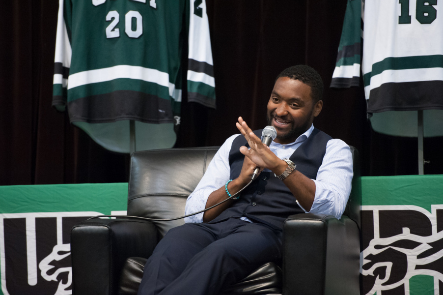Joel Ward A man laughs as he speaks into a microphone