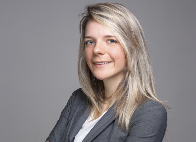 Krystin Matters A portrait of a smiling young woman with long hair and a grey suit
