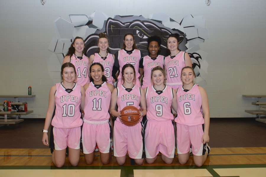 The UPEI Women's Basketball team A posed image of ten female basketball players wearing pink jerseys