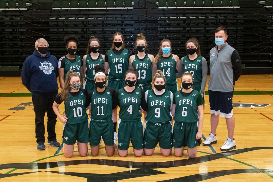 All members of the women's basketball team achieved Academic All-Canadian status for 2020–21 Photo of women's basketball team standing with coaches in the gym