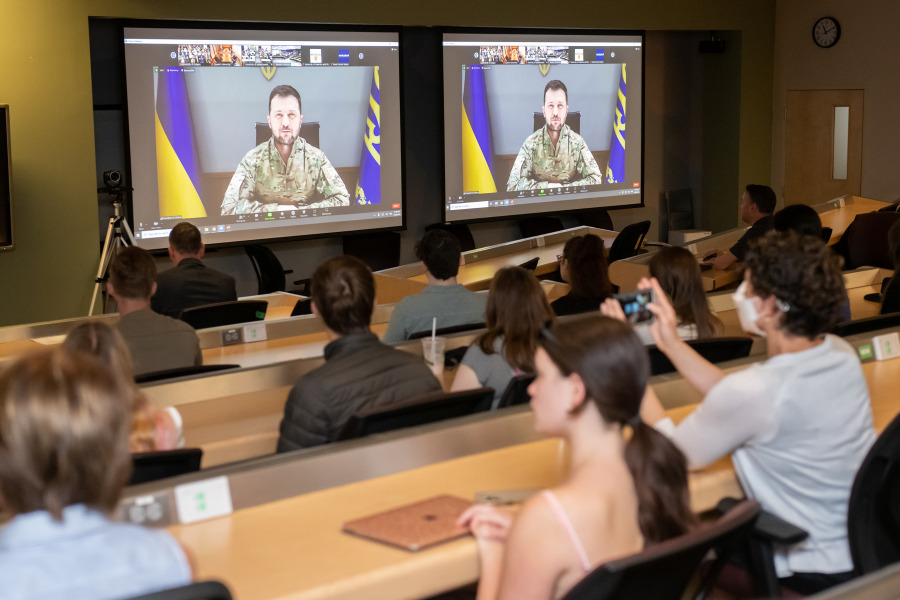 Members of the UPEI community gathered at AVC on June 22 to participate in an interactive event with President Volodymyr Zelenskyy image of students in classroom watching two screens