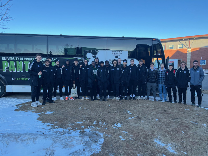 The UPEI Men's Basketball team prepares to board the Panther bus for the airport. They compete at the U SPORTS national men's basketball championship in Vancouver March 13–16. photo of team in front of a branded motor coach bus